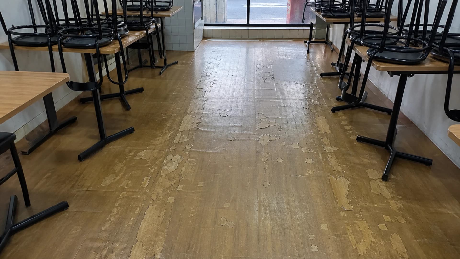 Cafe vinyl floor with a yellowed, peeling old coating