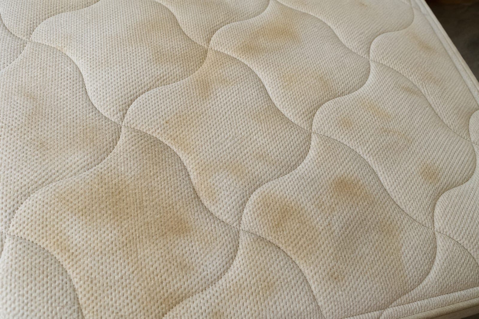 Guestroom mattress — visibly stained and worn