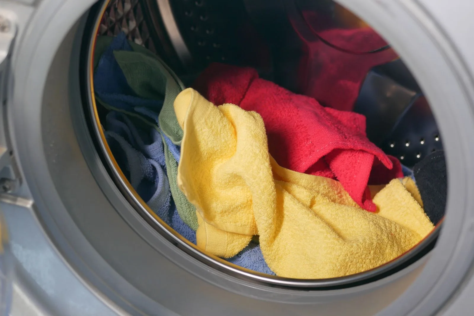 Kain dan tuala dalam mesin basuh untuk cuci dengan air panas