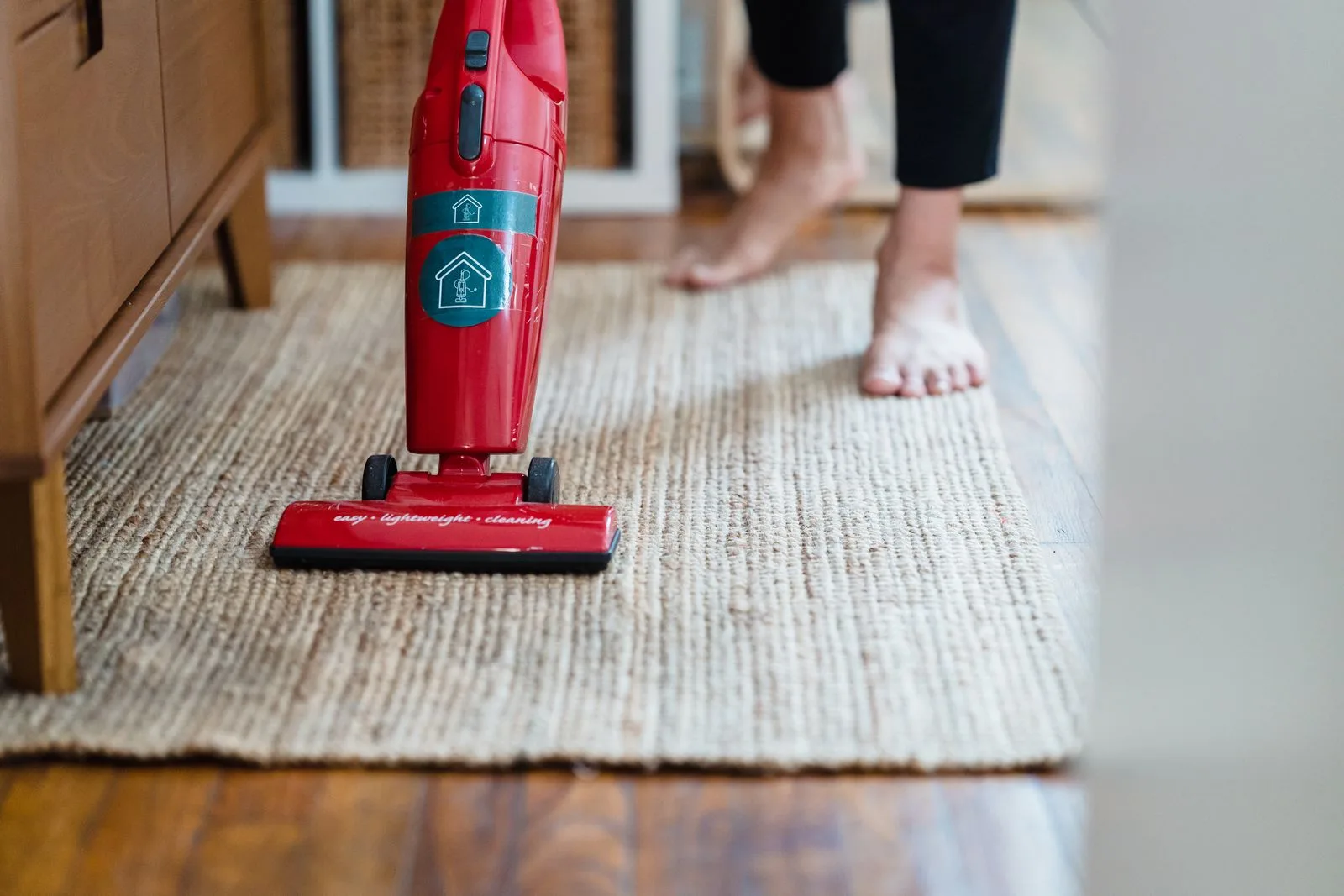 A person vacuuming a carpet in a living room